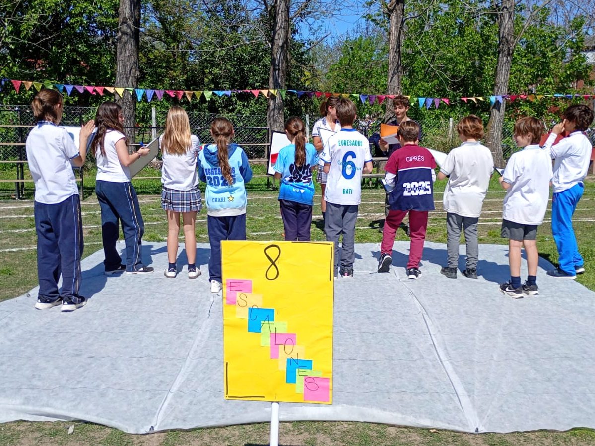 Alumnos en uno de los stands de la Kermese, al aire libre y bajo guirnaldas de banderines